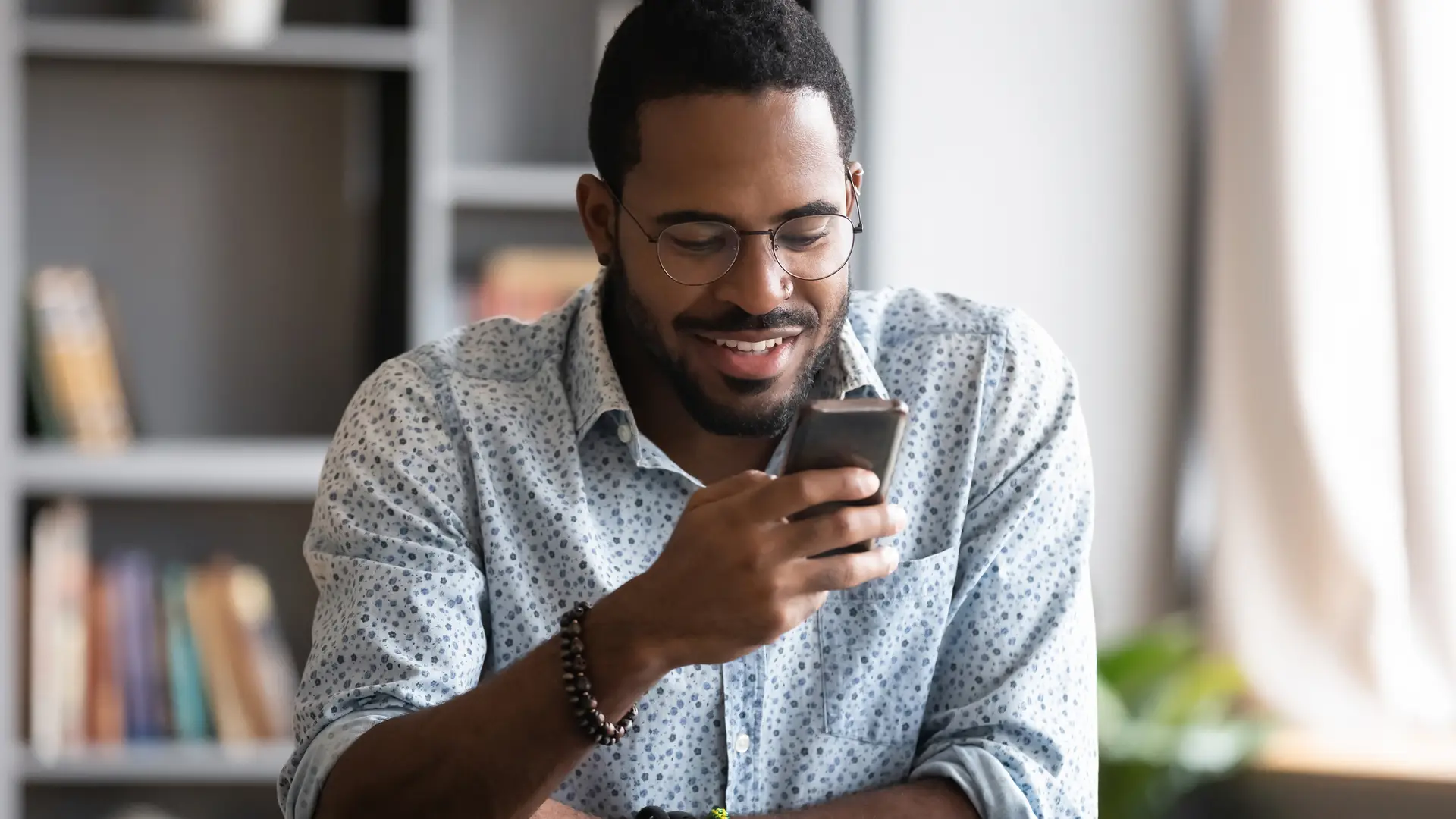 Hombre sonriente intentando averiguar su número de llamaya Hombre sonriente intentando averiguar su número de llamaya