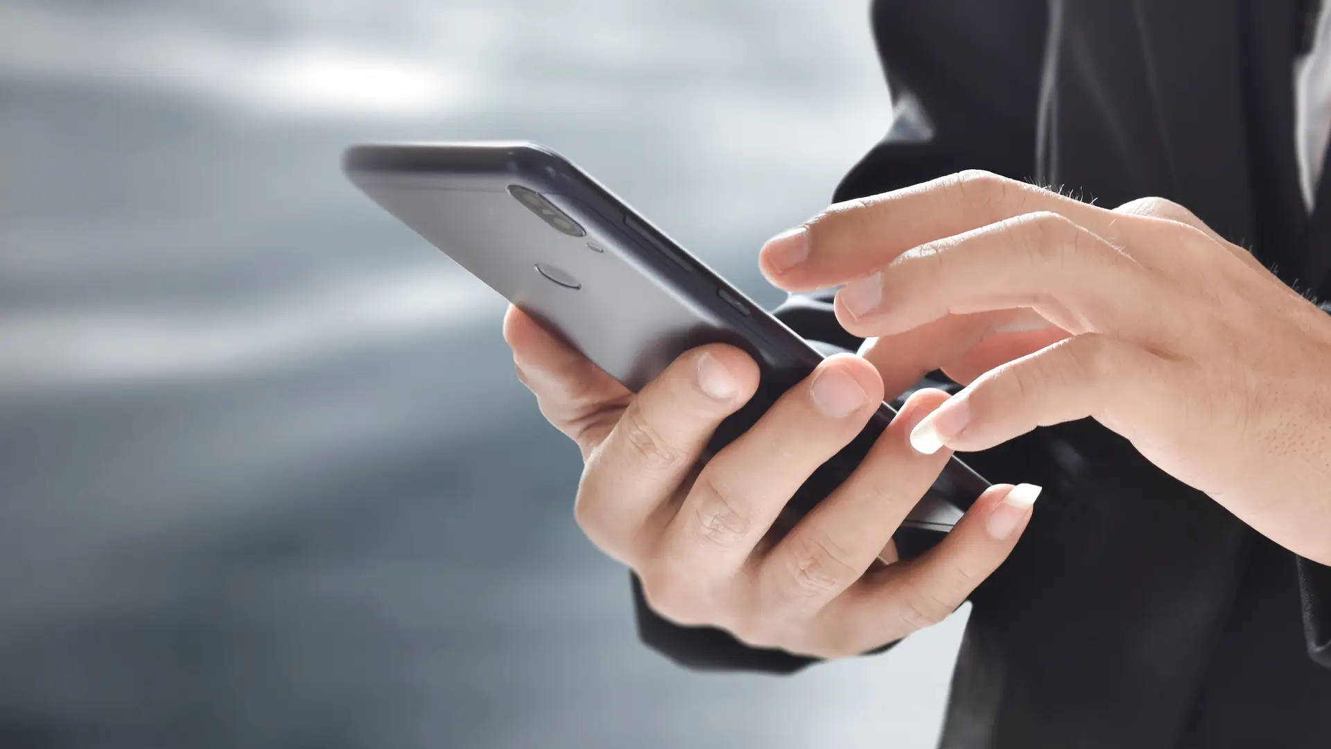 Hombre sosteniendo y usando el teléfono móvil simboliza tarifas móvil e internet de llamaya Hombre sosteniendo y usando el teléfono móvil simboliza tarifas móvil e internet de llamaya