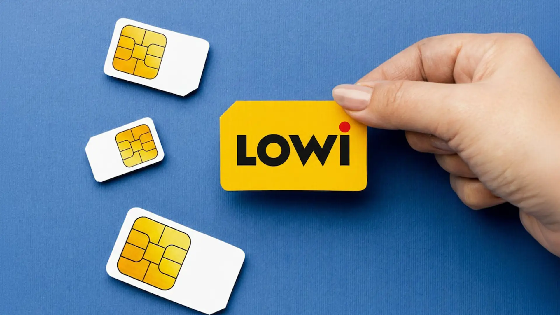 Mano sosteniendo una tarjeta SIM de la operadora de telefonía móvil Lowi sobre un fondo azul.
