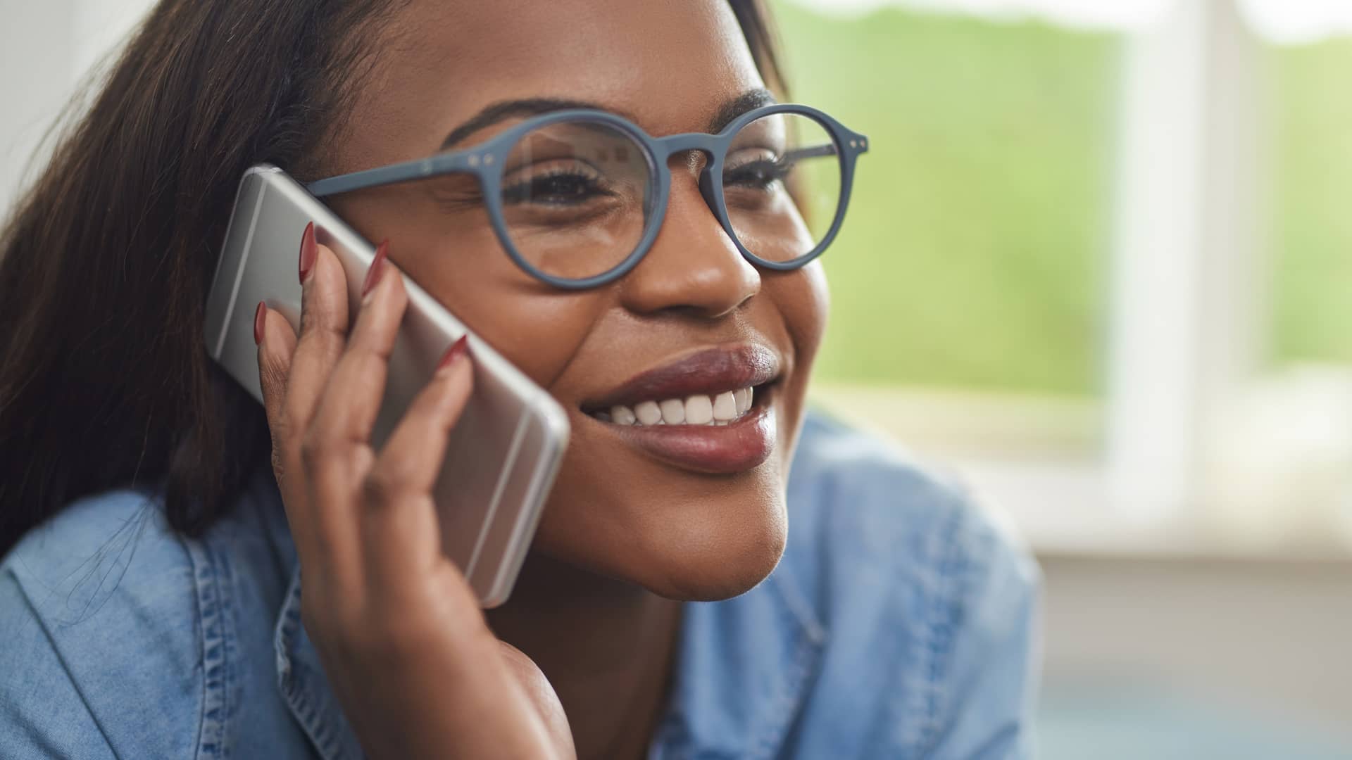 Mujer sonriente manteniendo una conversación distendida por teléfono represeta llamadas ilimitadas