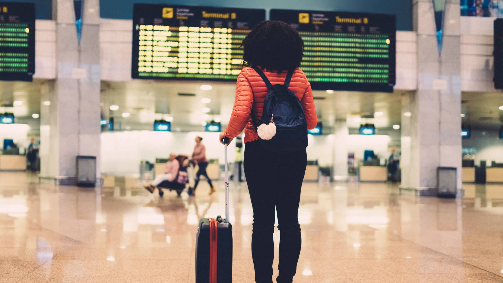 Mujer en el aeropuerto revisando la tabla de salida simboliza roaming de lowi