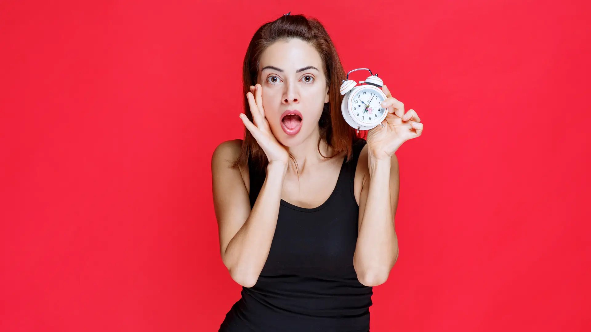 Mujer susurra mientras sujeta un reloj representando la permanencia que aun tiene con su tarifa de lowi Mujer susurra mientras sujeta un reloj representando la permanencia que aun tiene con su tarifa de lowi