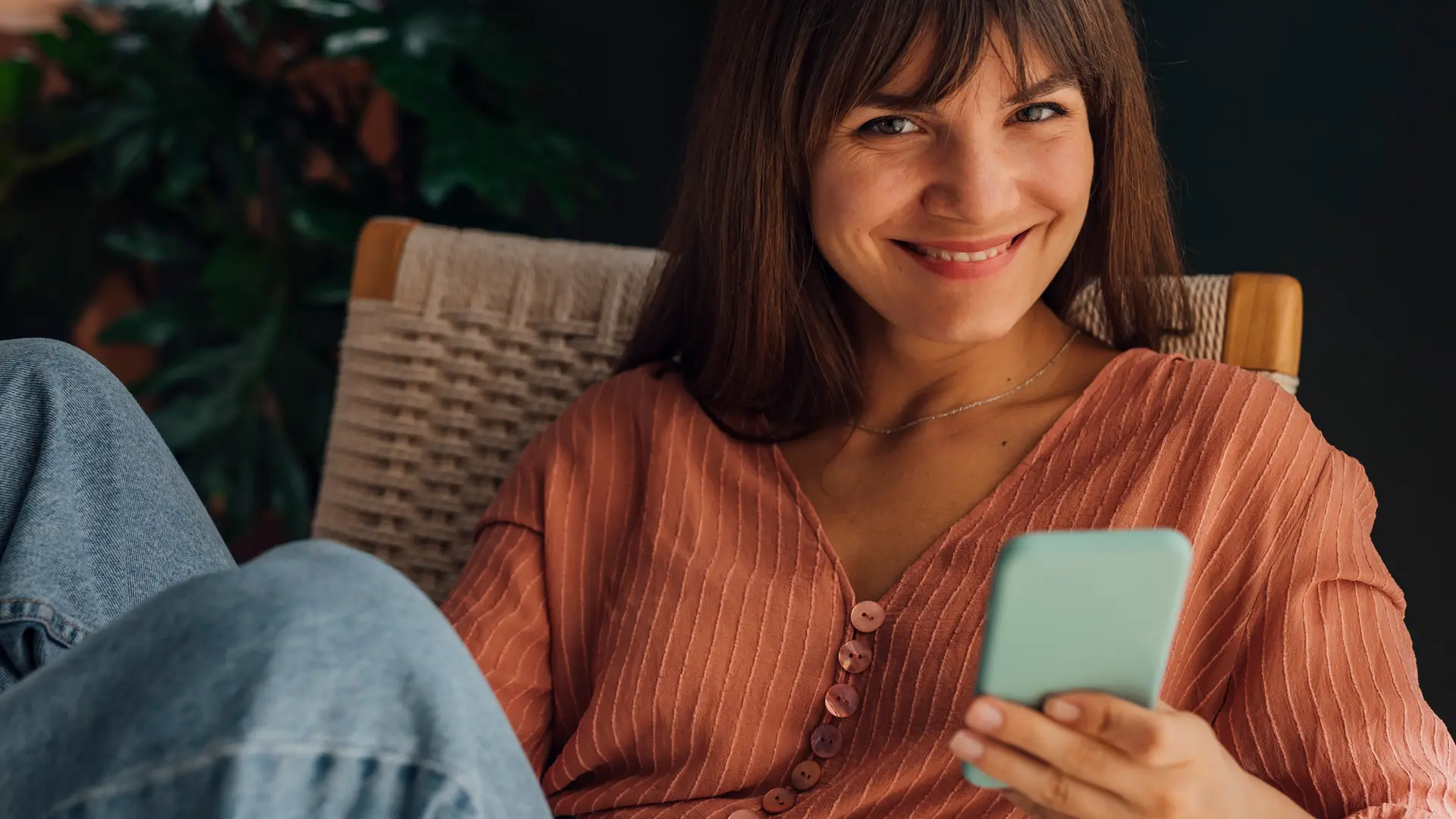 Mujer sonriente navegando con su móvil representa móvil internet de lowi Mujer sonriente navegando con su móvil representa móvil internet de lowi