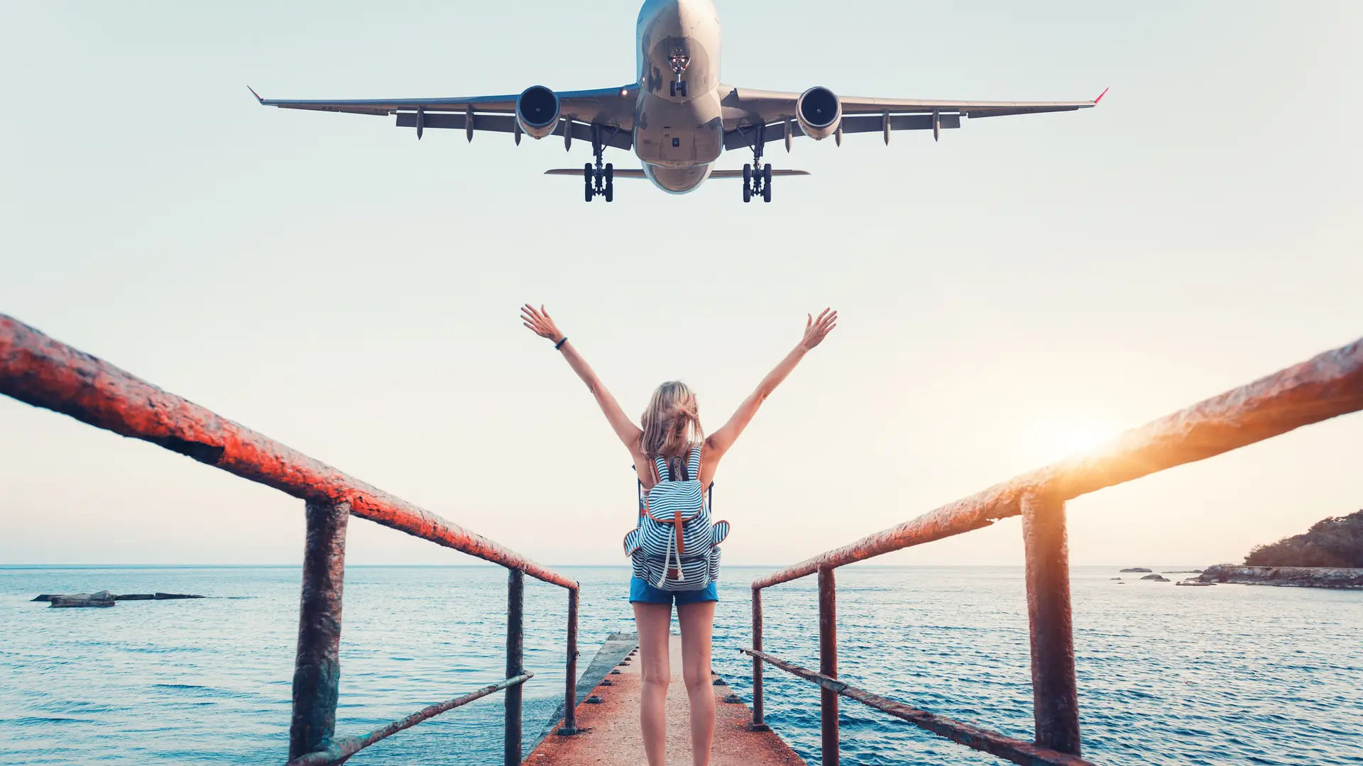 Mujer en una pasarela hacia el mar diciendo adiós a un avión simboliza el roaming de lycamobile Mujer en una pasarela hacia el mar diciendo adiós a un avión simboliza el roaming de lycamobile