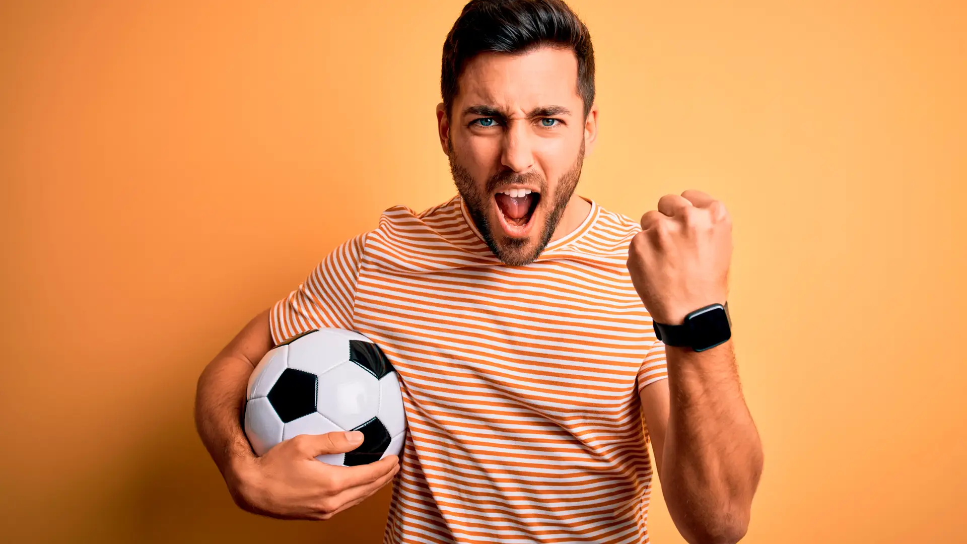 Joven con balón de fútbol y cara de celebración representa fútbol televisión másmovil Joven con balón de fútbol y cara de celebración representa fútbol televisión másmovil