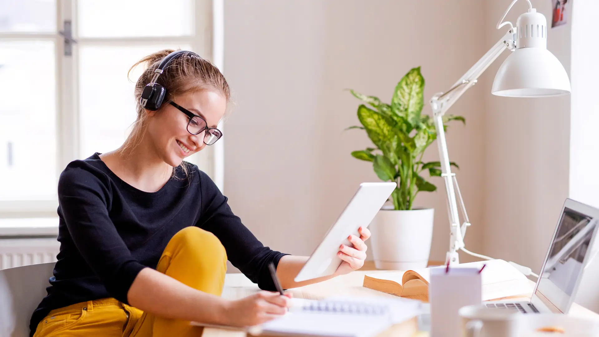 Mujer revisando facturas en su tablet mientras escucha música Mujer revisando facturas en su tablet mientras escucha música