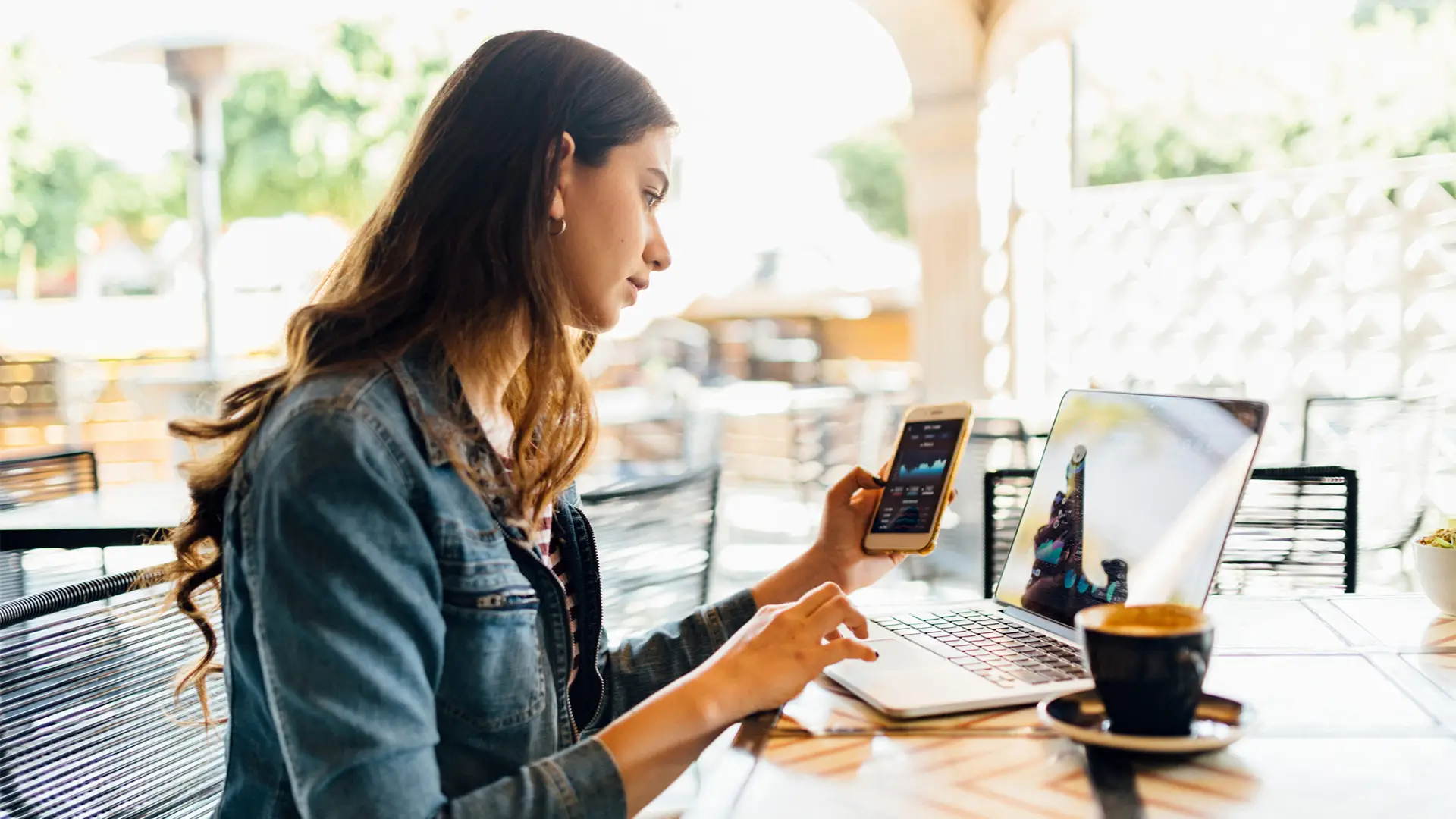 Mujer compartiendo datos desde su móvil a su laptop Mujer compartiendo datos desde su móvil a su laptop