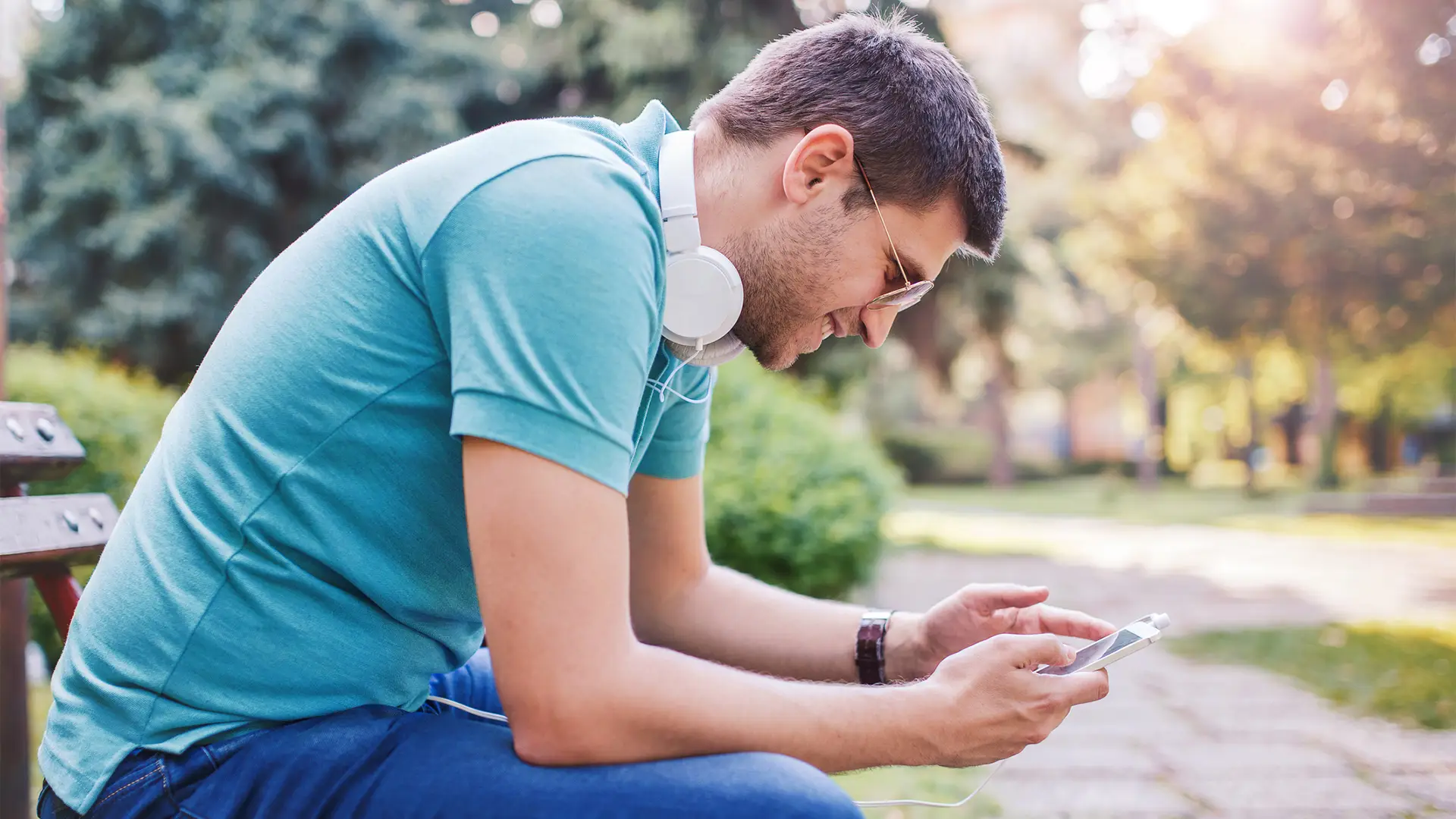 Joven padre pasando saldo al teléfono de su hijo Joven padre pasando saldo al teléfono de su hijo