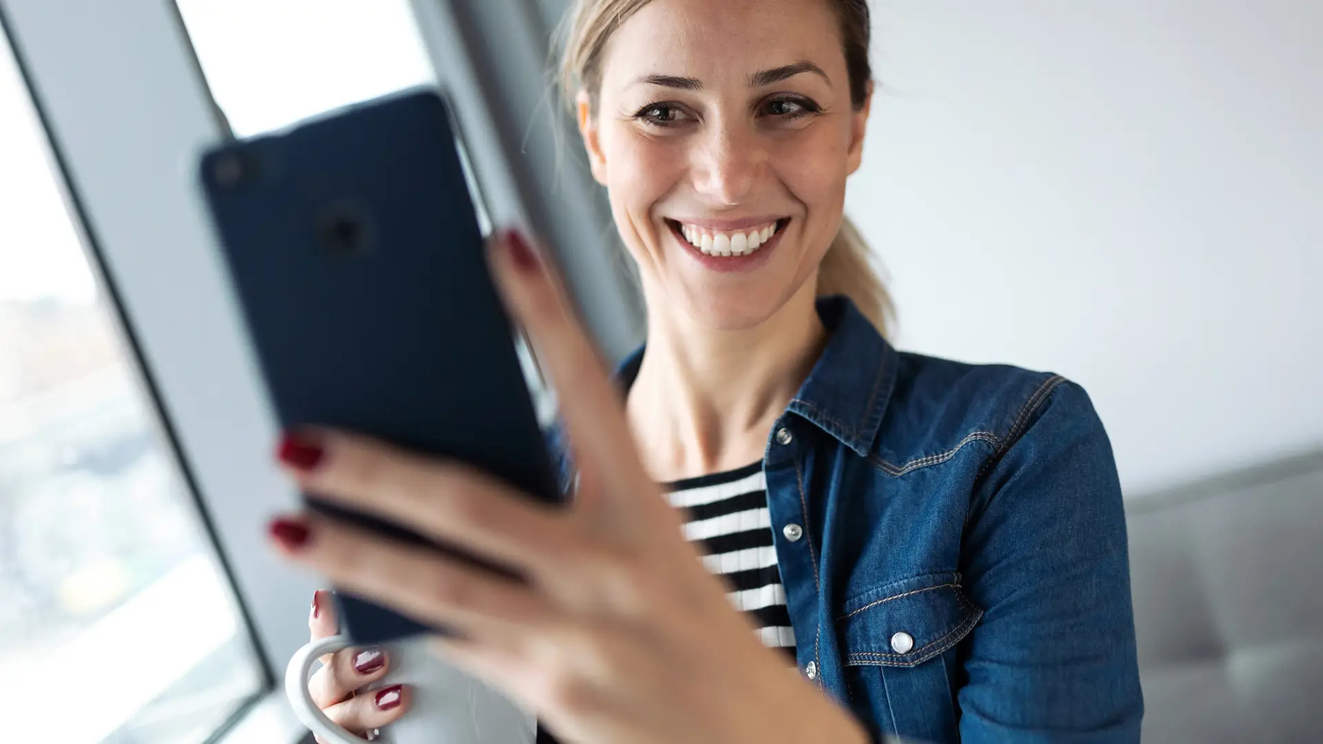 Joven contenta al recibir un sms en su smartphone Joven contenta al recibir un sms en su smartphone