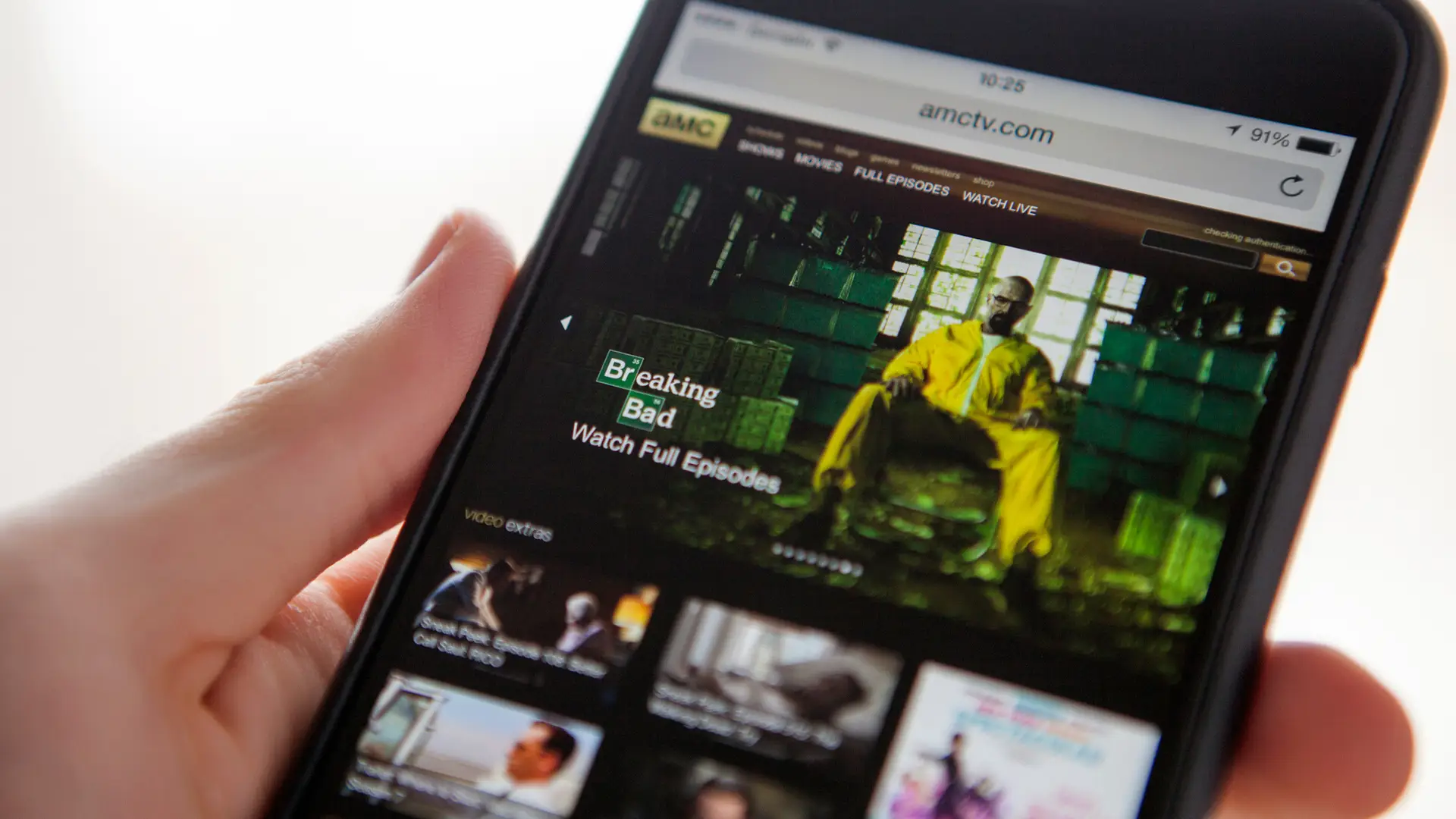 Joven viendo programación canal amc en su teléfono Joven viendo programación canal amc en su teléfono