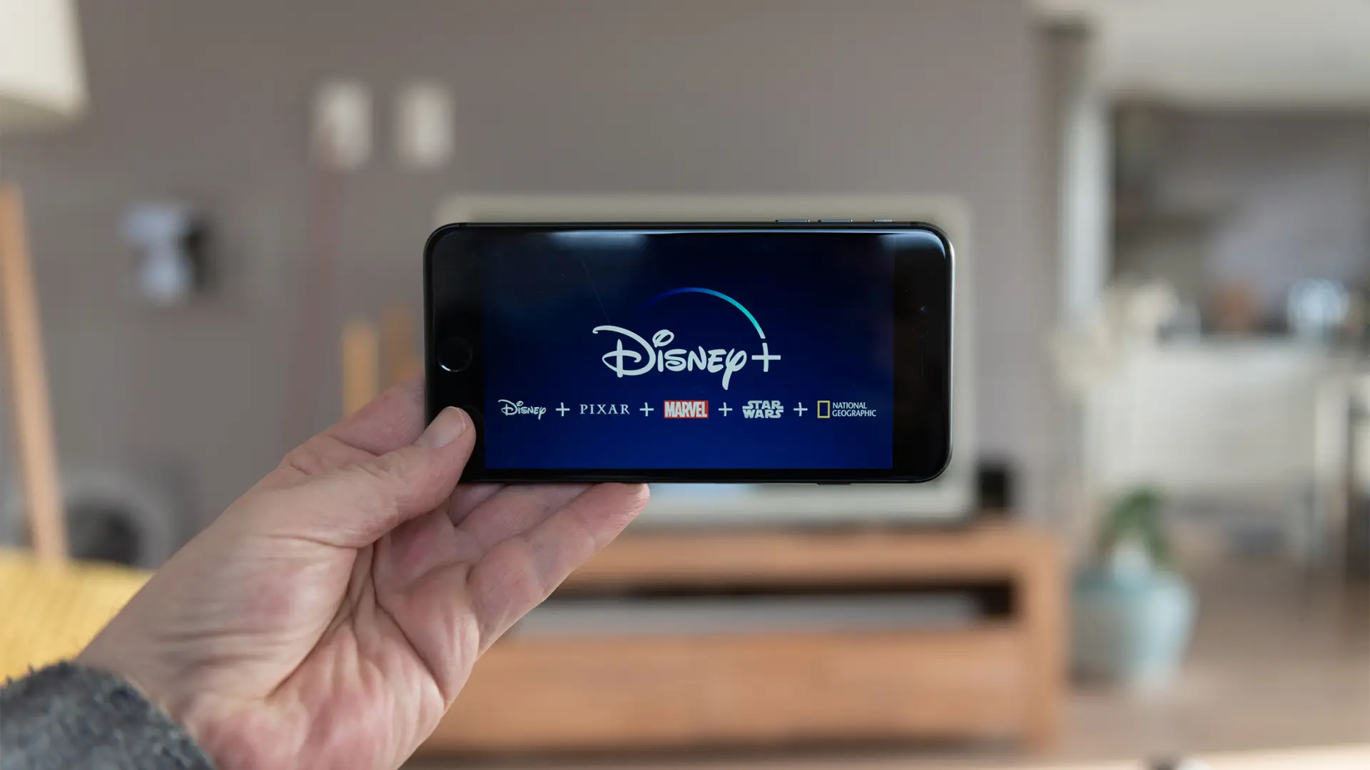 Persona viendo disney plus en su smartphone Persona viendo disney plus en su smartphone
