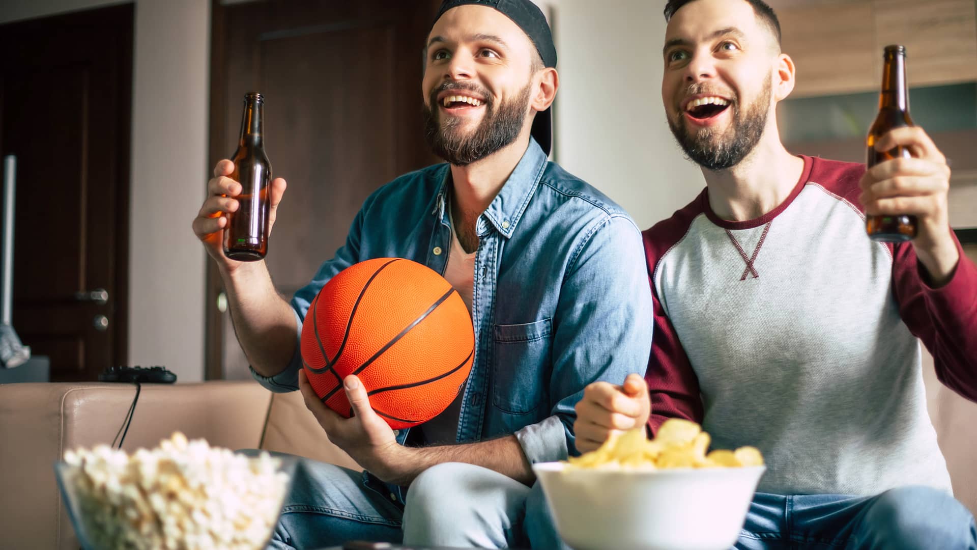Dos amigos disfrutan de un partido de la NBA en su televisión gracias a movistar+