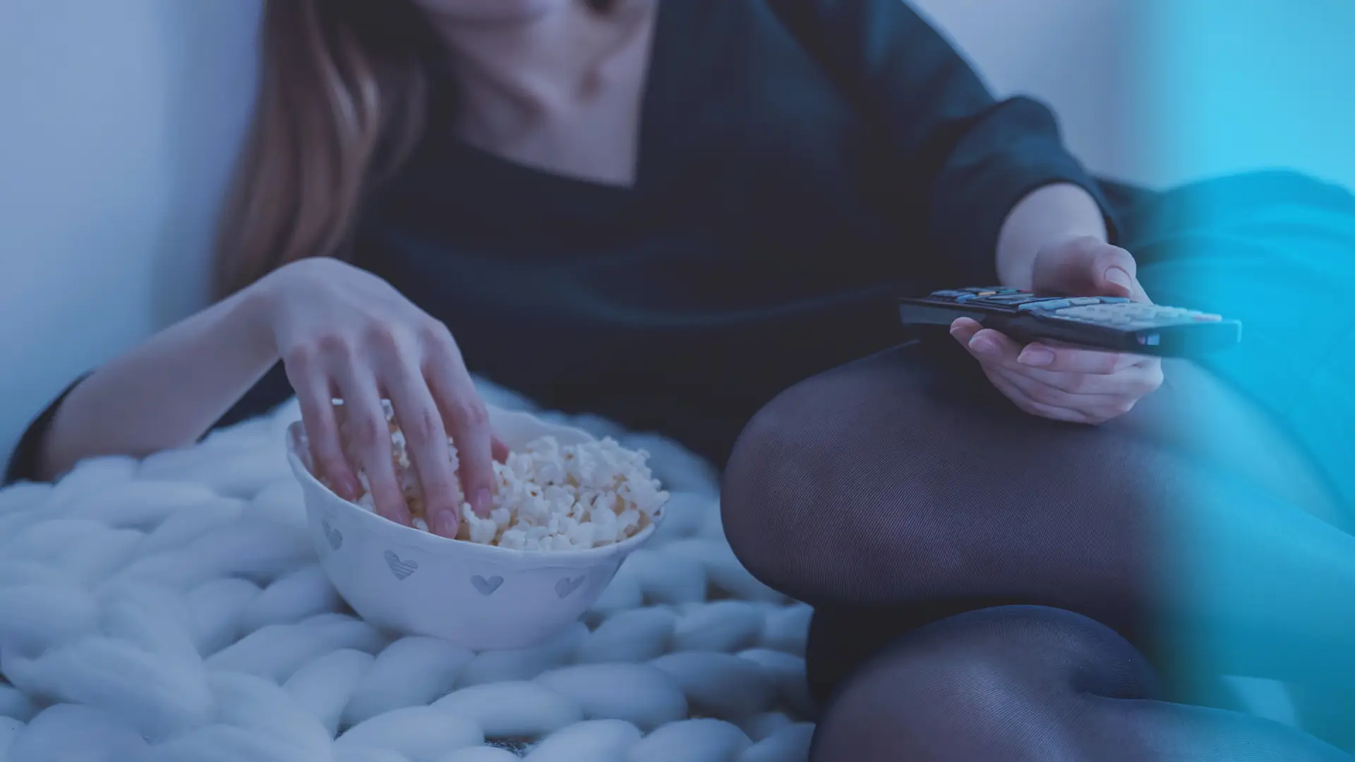Mujer viendo película con subtítulos mientras come palomitas