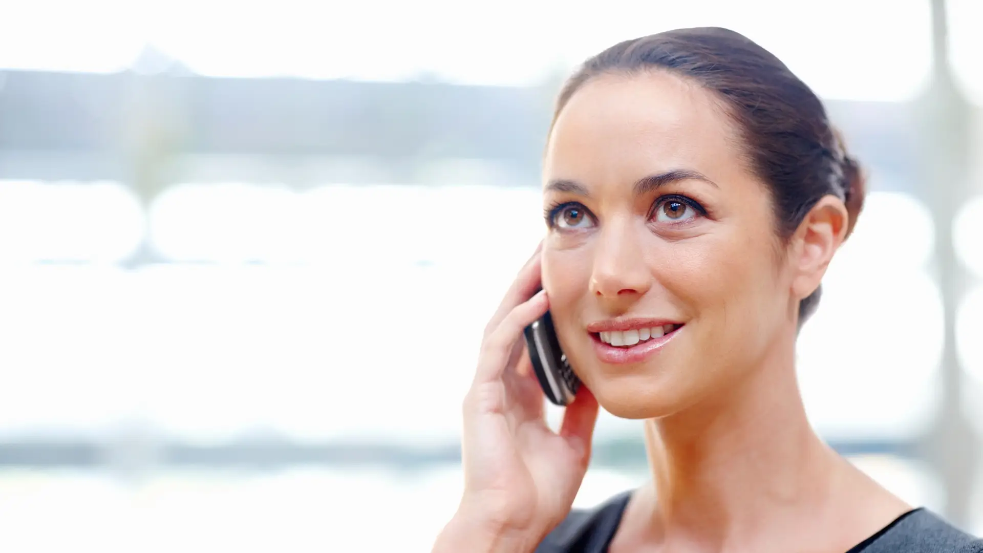 Mujer hablando por teléfono para realizar un cambio de tarifa Mujer hablando por teléfono para realizar un cambio de tarifa
