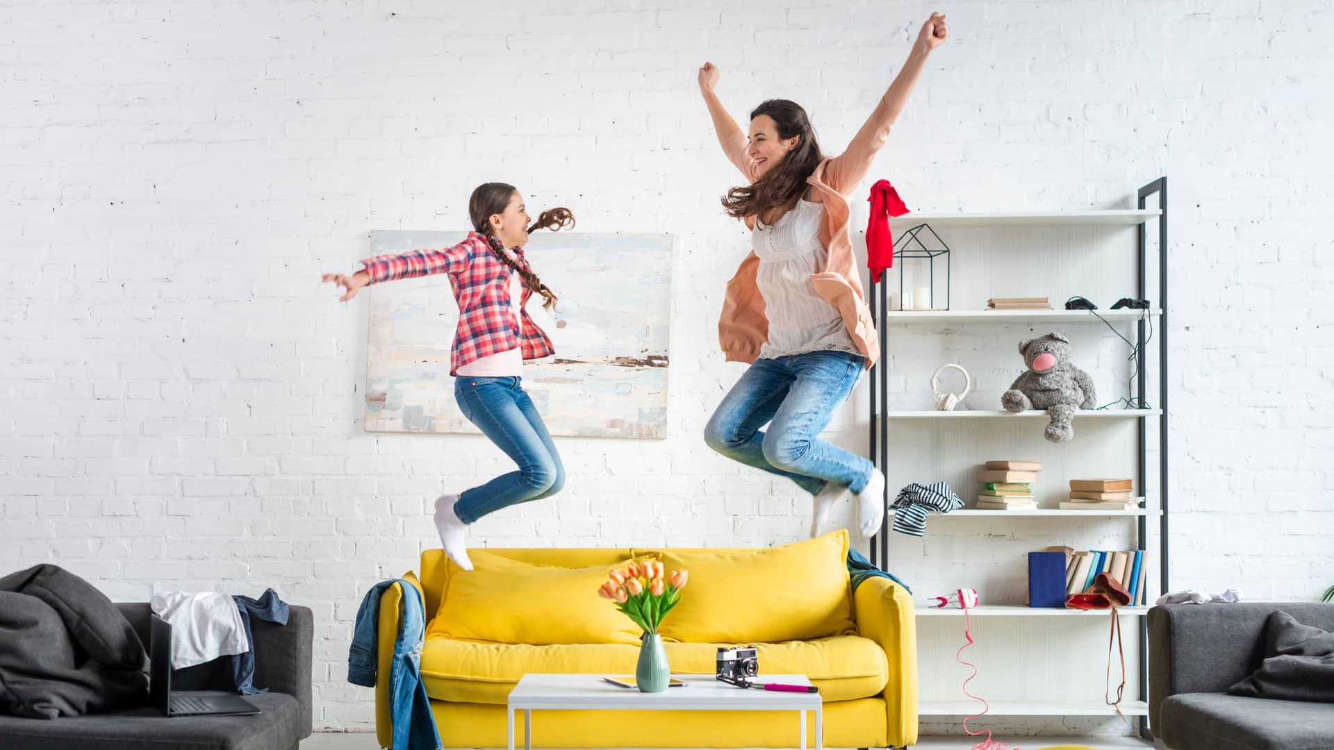 Madre e hija saltan en el sofá de alegría tras descubrir las ofertas de movistar en fibra. móviles y alarmas