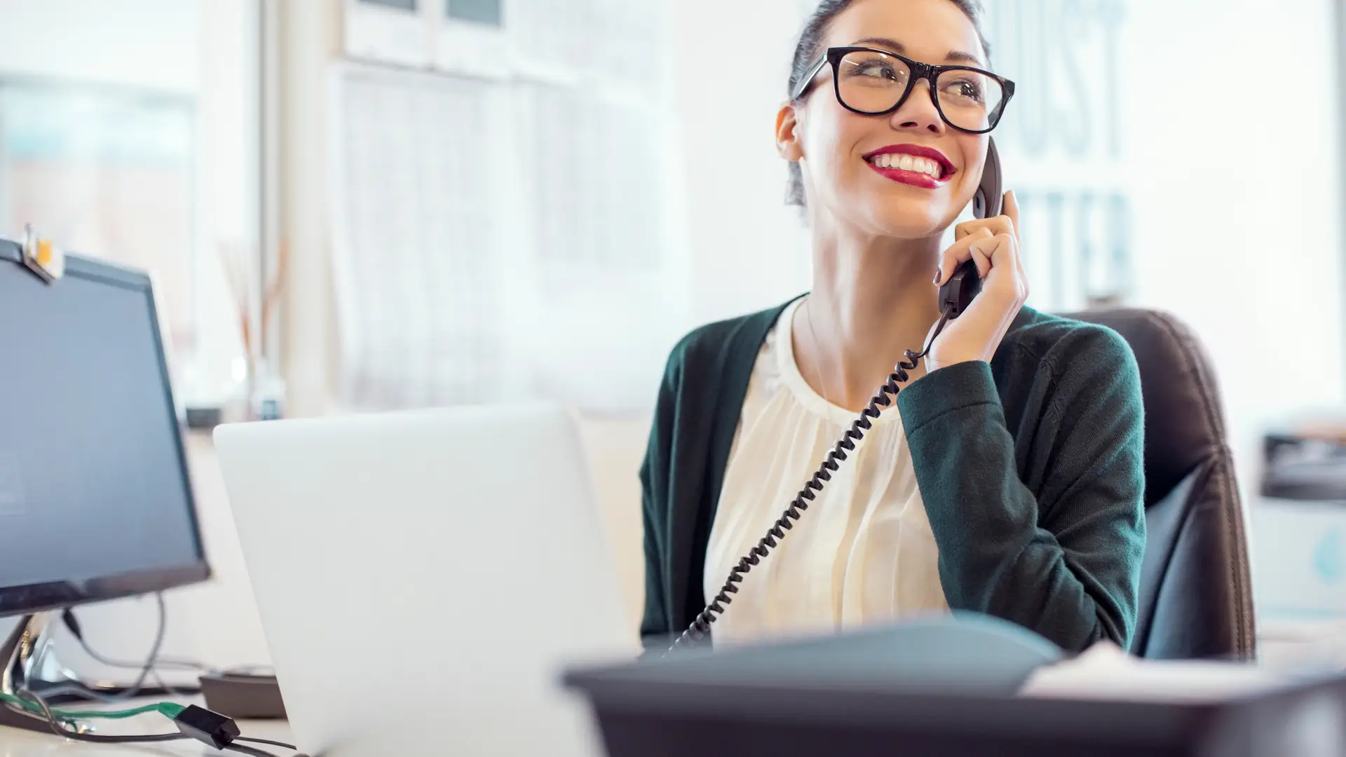 Joven en oficina usando teléfono fijo simboliza tarifas fijo compañía mundor