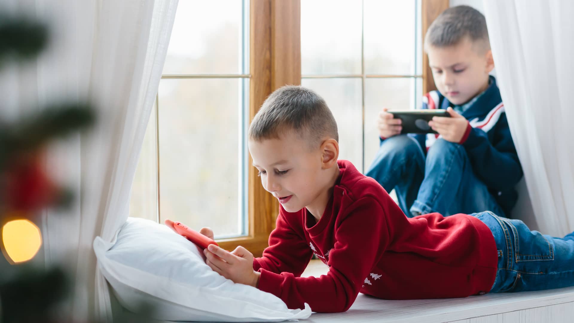 Dos hermanos pequeños juegan en línea tras compartir los datos de su tarifa o2