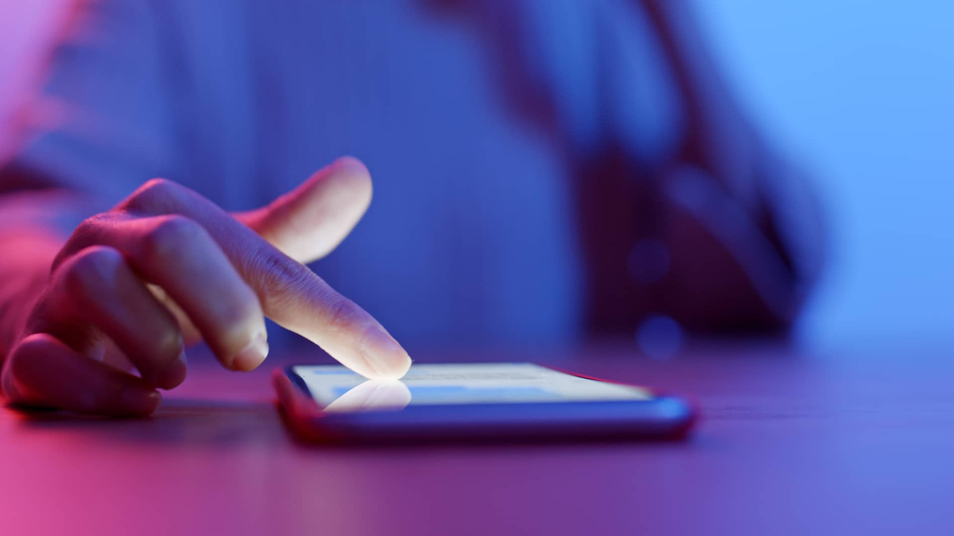Manos de una persona tocando la pantalla de un smartphone para representar commo adquirir moviles con la compañia o2