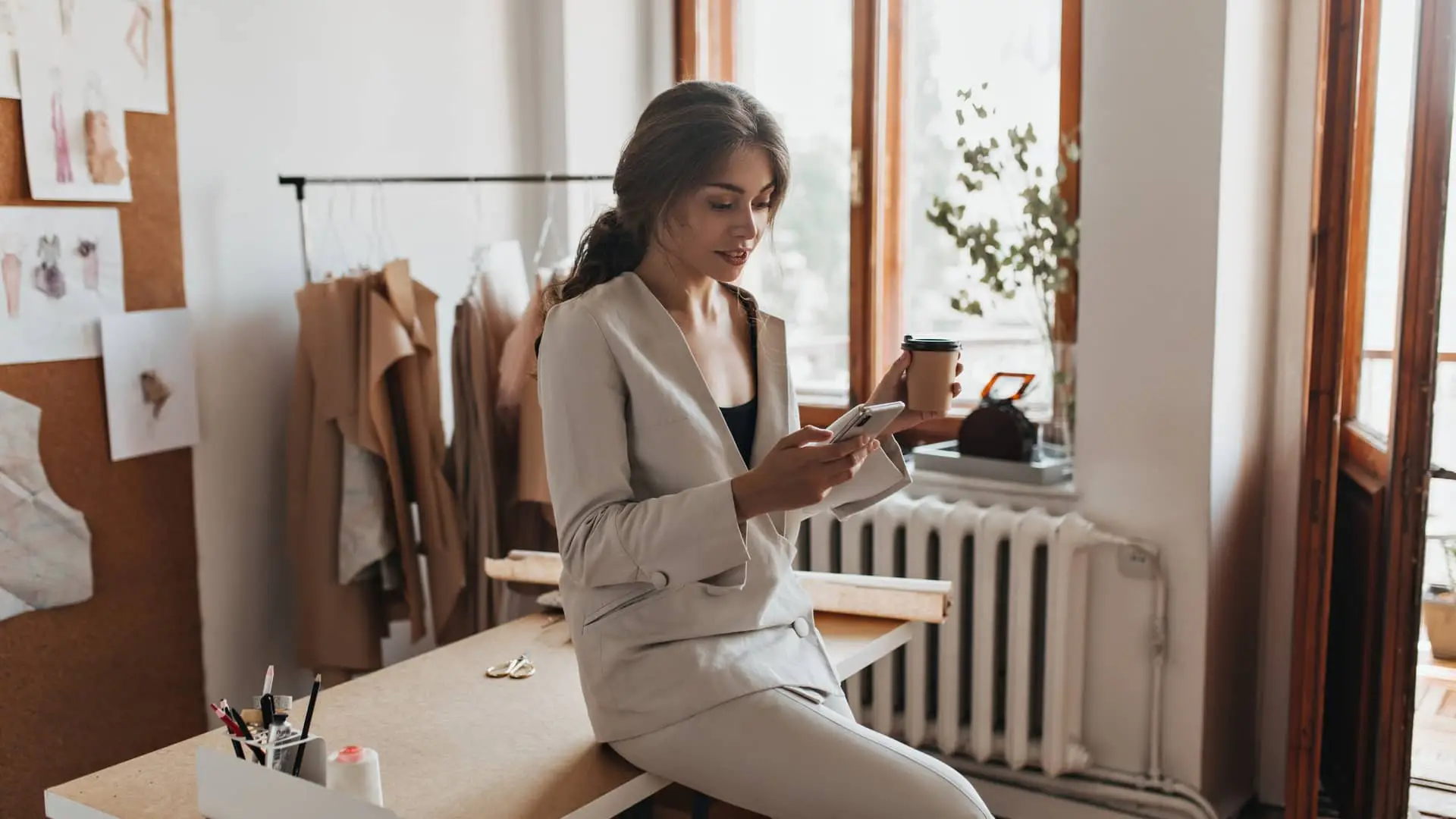 Pequeña empresaria consultando pedidos de moda en su móvil gracias a su contrato de Orange empresas, conecta pymes Pequeña empresaria consultando pedidos de moda en su móvil gracias a su contrato de Orange empresas, conecta pymes