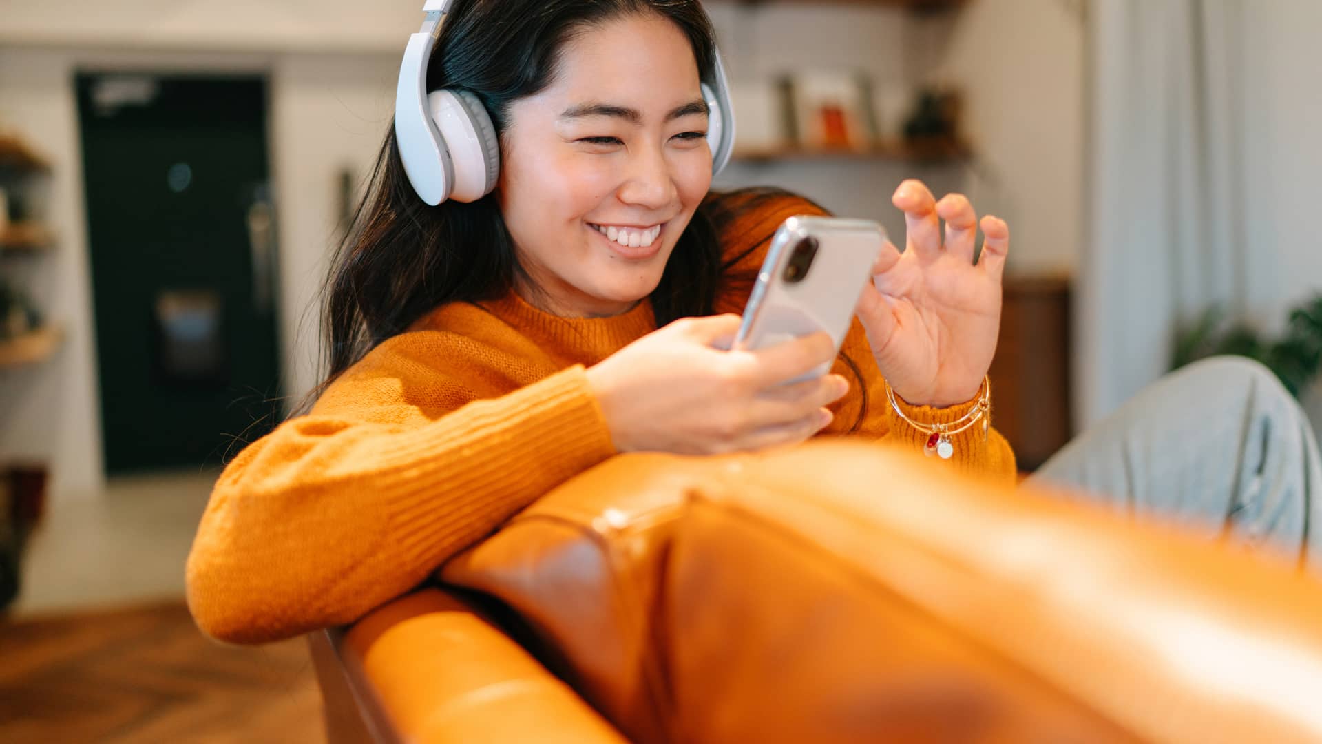Elegante joven escuchando música en casa con gigas gratis de orange