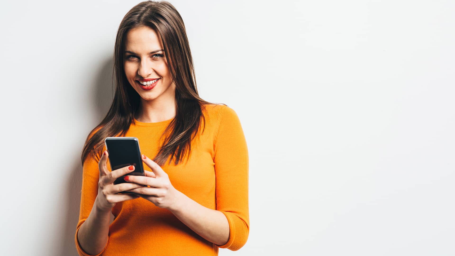 Mujer sonriente utilizando su móvil libre