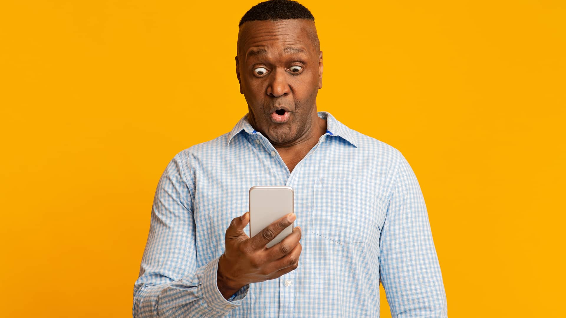 Hombre con su smartphone con cara de asombro al descubrir las ofertas renove de orange