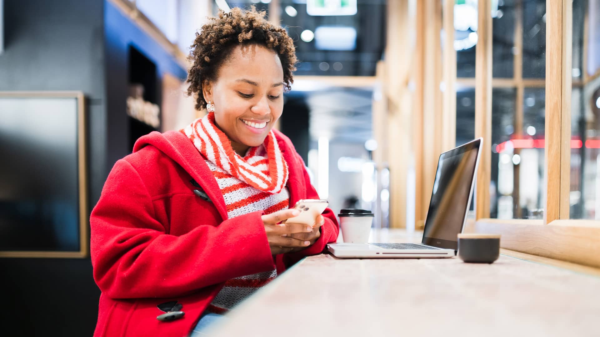 Mujer usando su smartphone para compartir datos para navegar con su laptop