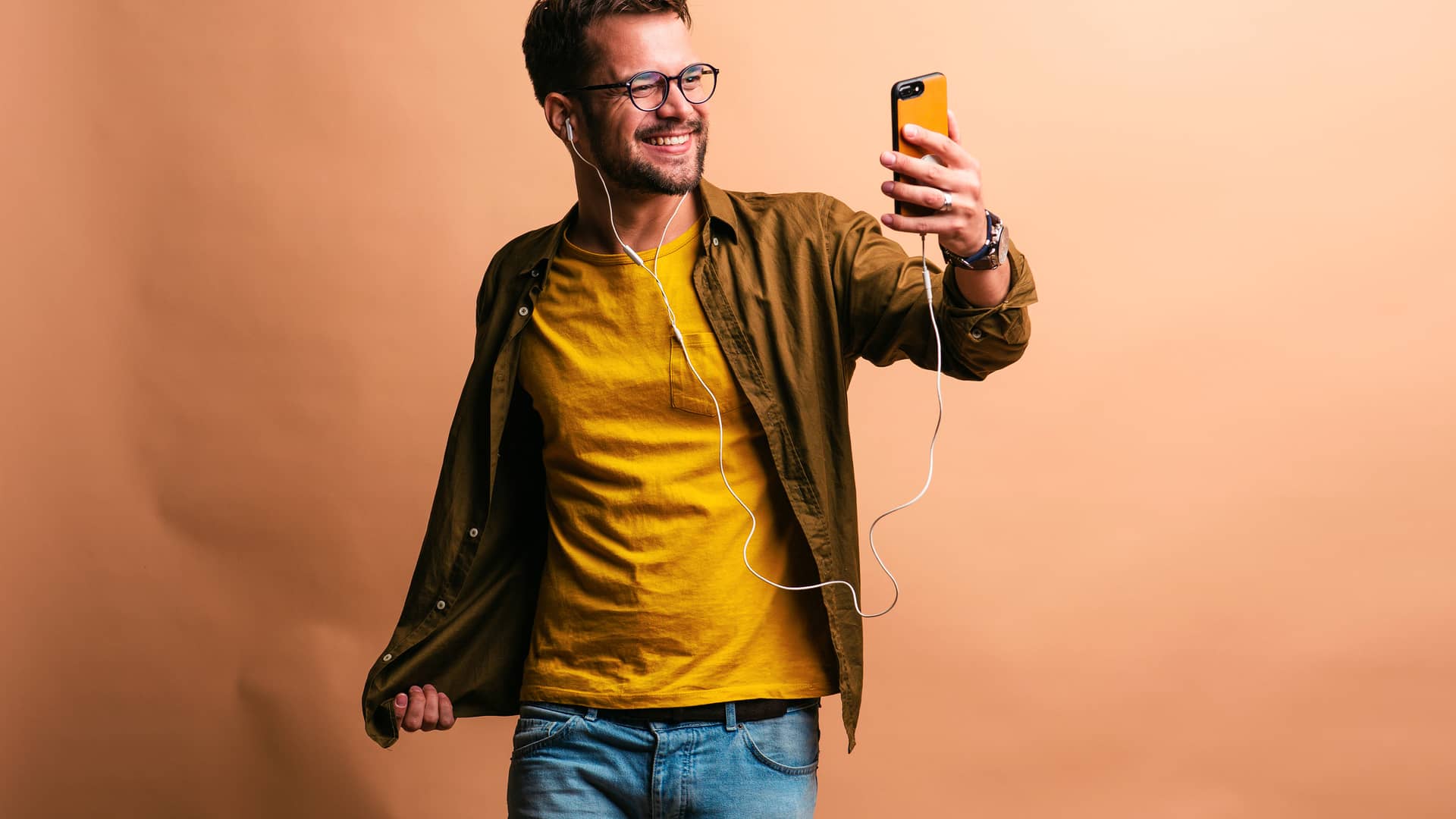 Joven feliz escuchando música en su smartphone simboliza 10gb gratis simyo