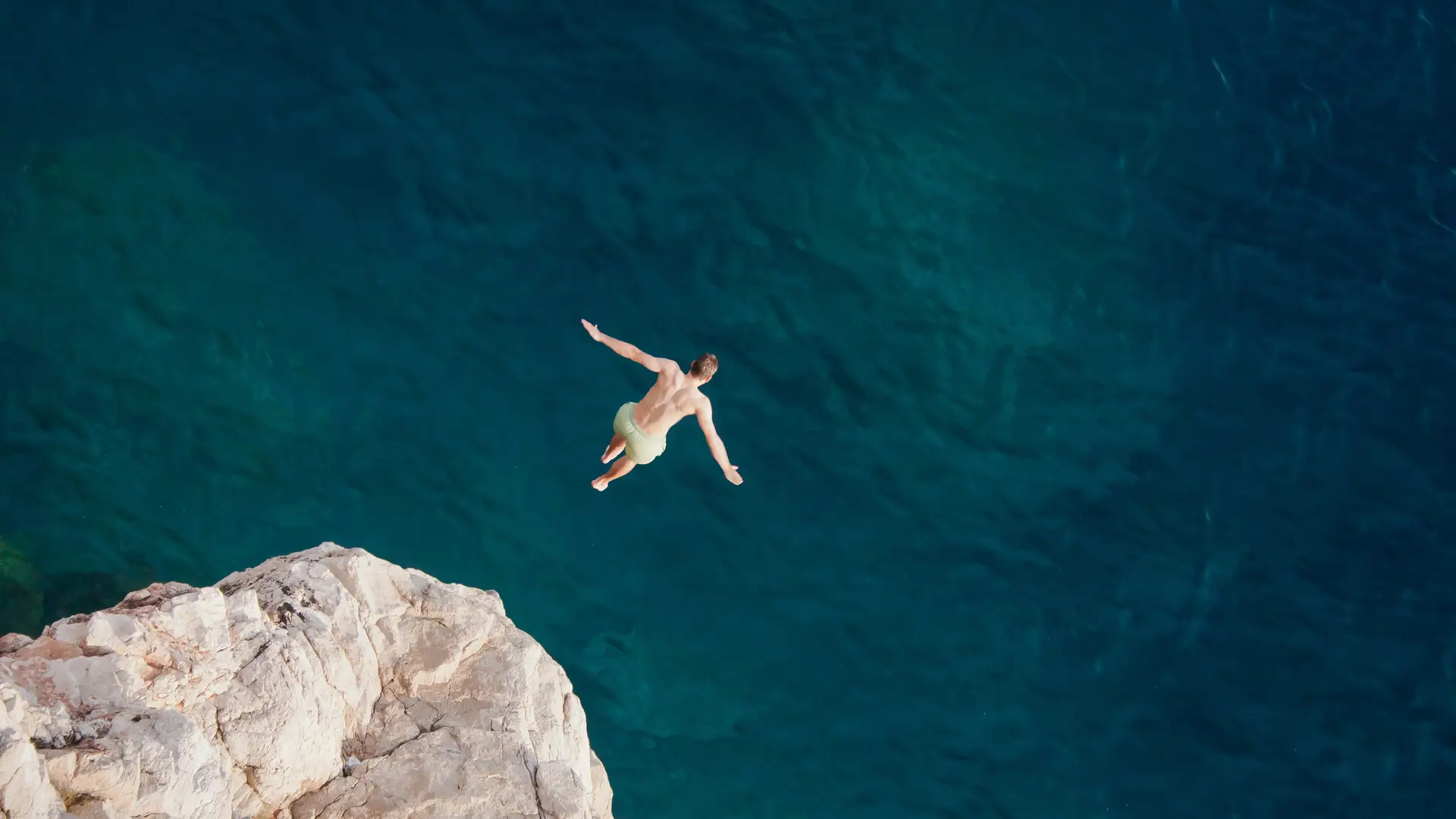 Joven saltando hacia el mar simboliza portabilidad compañía suop Joven saltando hacia el mar simboliza portabilidad compañía suop