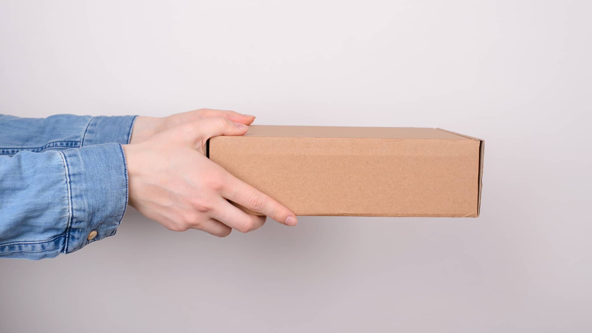 Persona con caja que contiene equipos vodafone a devolver