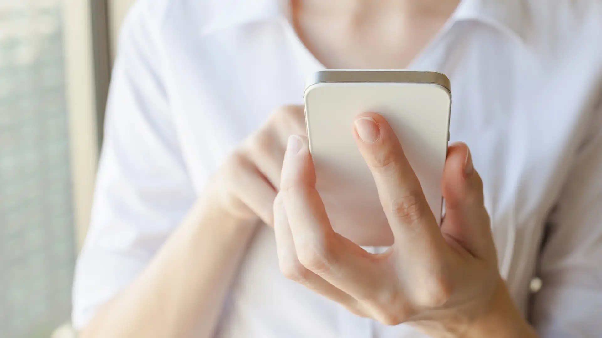 Mujer pagando con el móvil y cargando pago a terceros con vodafone