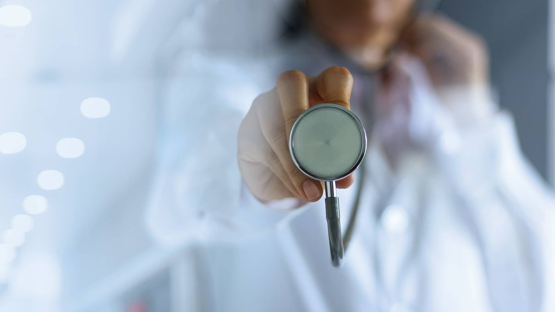 Medica con bata blanca utilizando un estetoscopio con el espectador representando a los medicos del servicio de doctorgo de yoigo