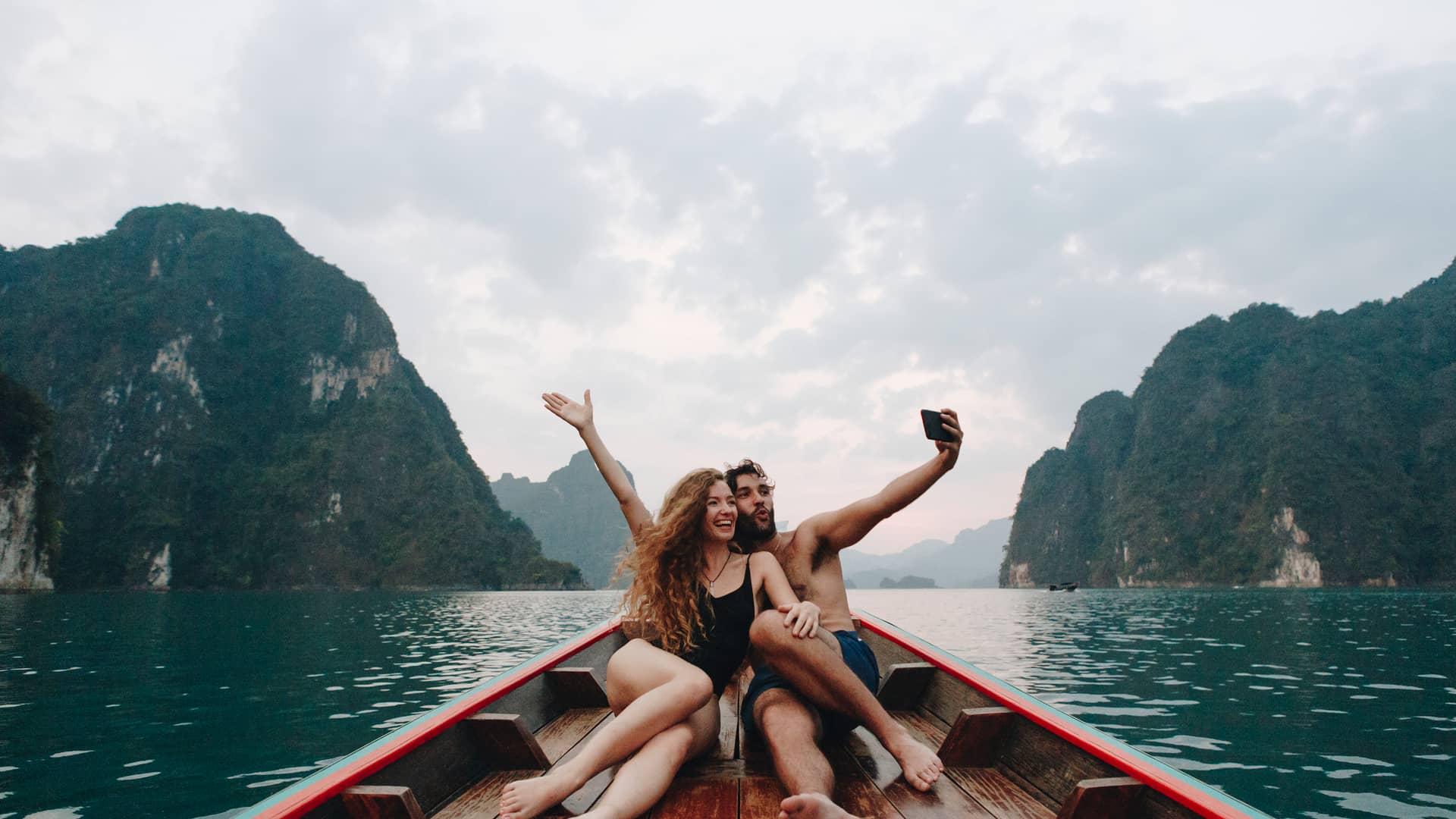 Pareja tomando selfie en un barco de cola larga representa gigas infinitos de yoigo
