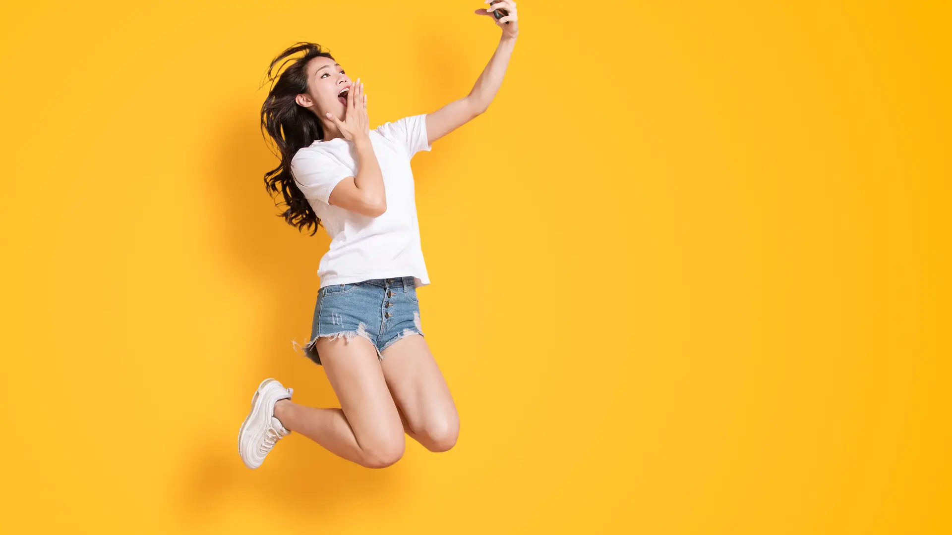 Joven saltando con smartphone representa portabilidad de yoigo Joven saltando con smartphone representa portabilidad de yoigo