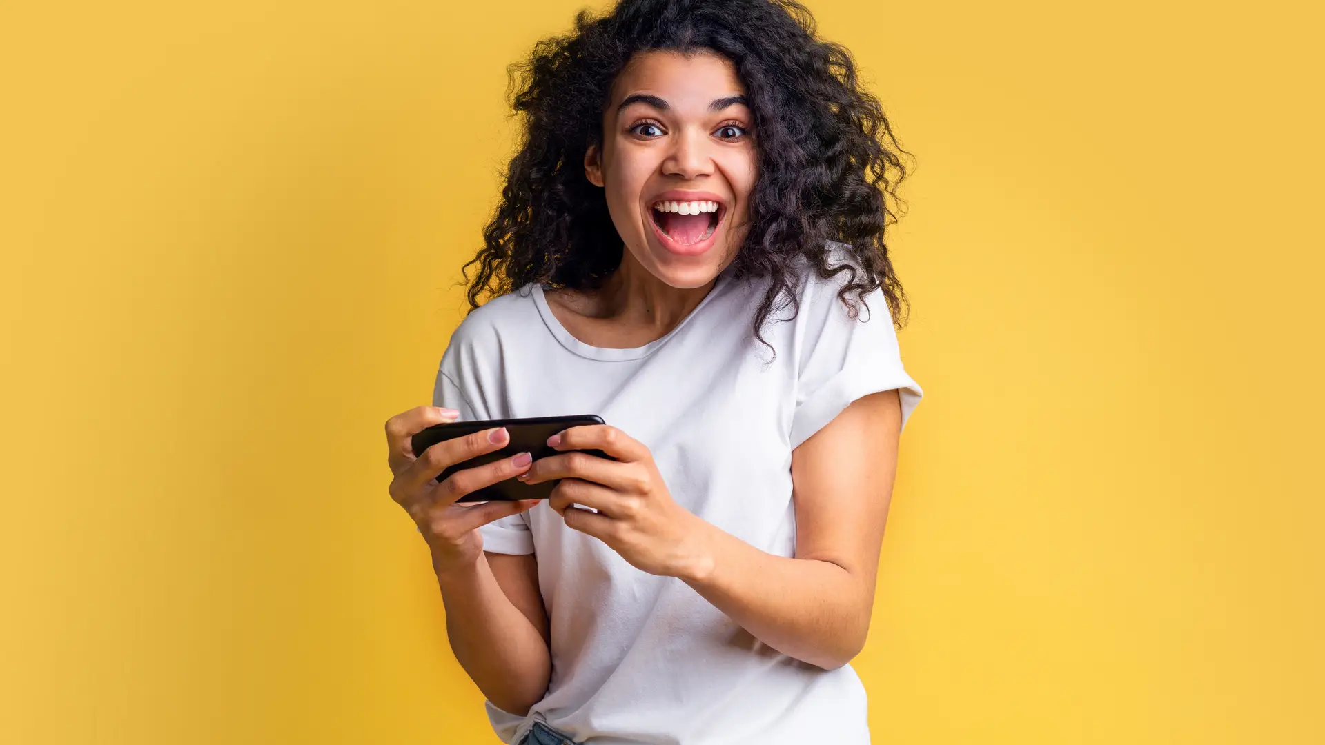 Joven feliz porque ha recibido una recarga en su smartphone Joven feliz porque ha recibido una recarga en su smartphone