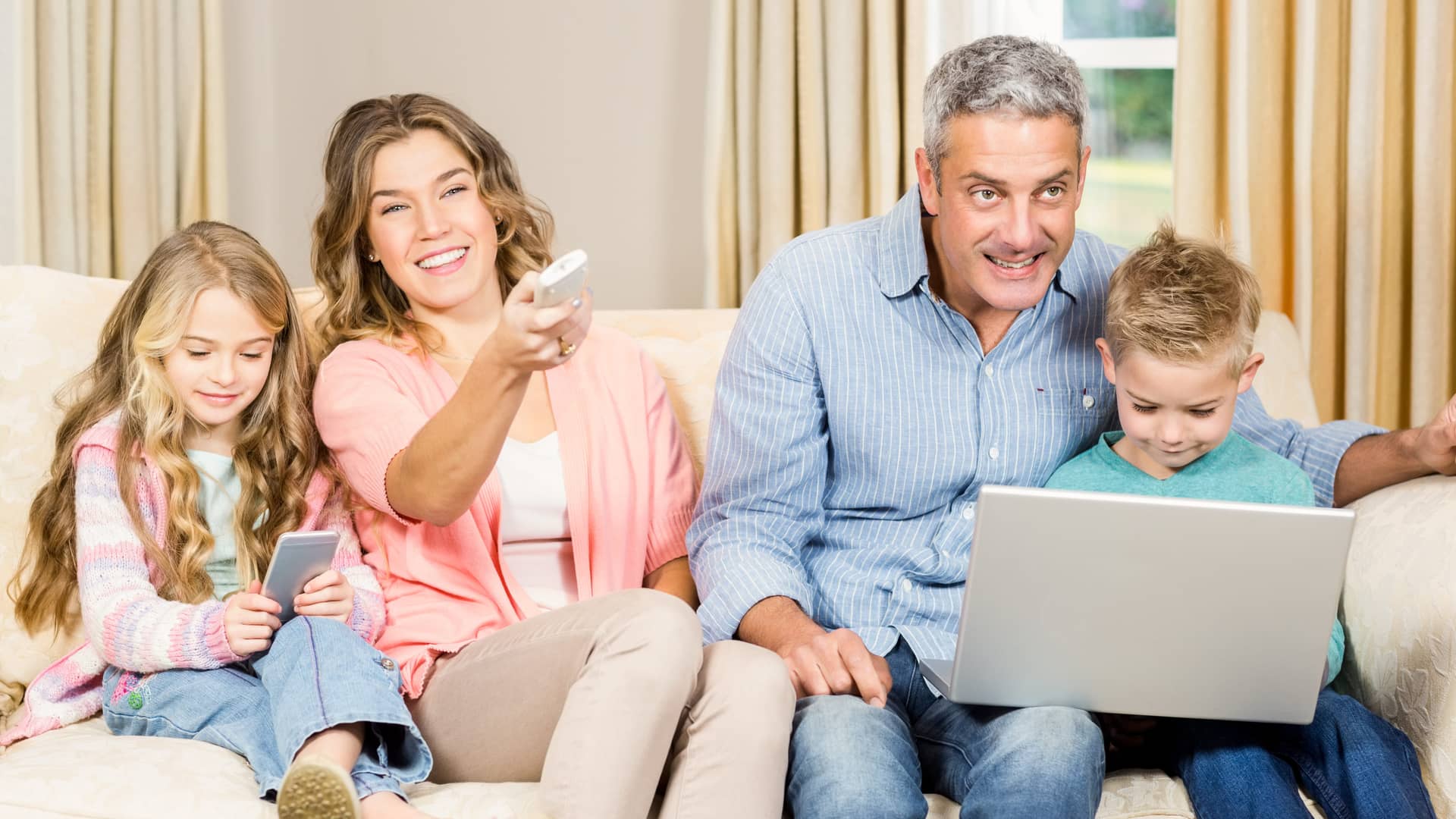familia en la que ven la tele, juegan con el movil y navegan en internet con el ordendor por sus tarifas