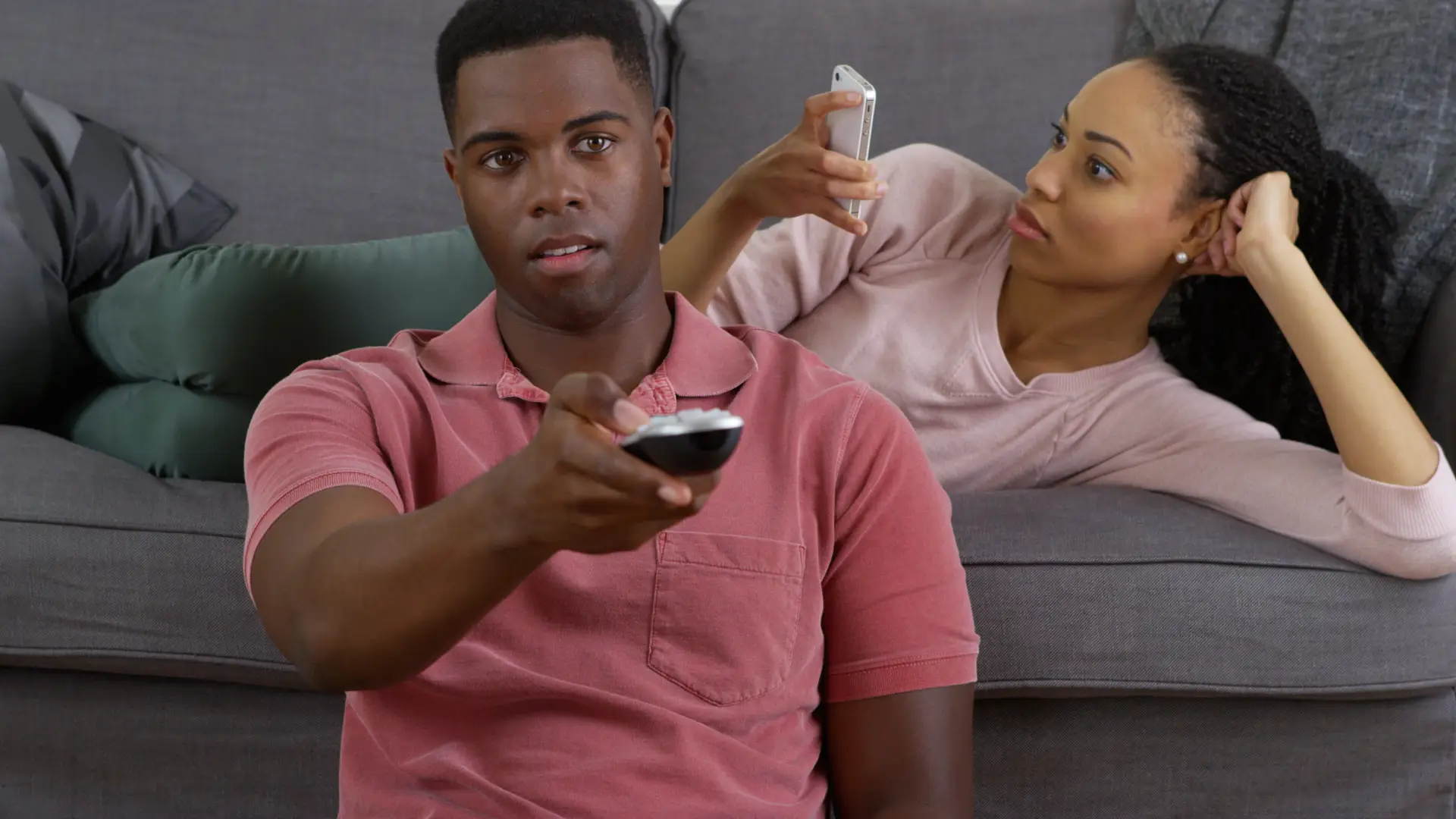 pareja en la que el ve la televisión y ella esta con el telefono movil porque conocen sus tarifas pareja en la que el ve la televisión y ella esta con el telefono movil porque conocen sus tarifas